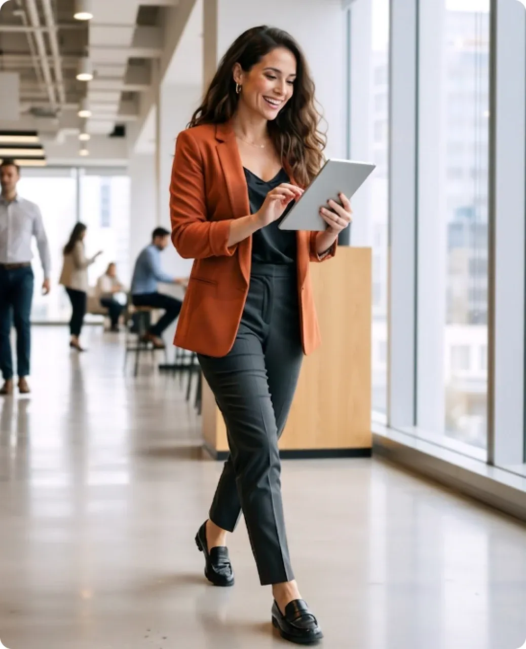A consultant walking through a bright office corridor, reading from a tablet