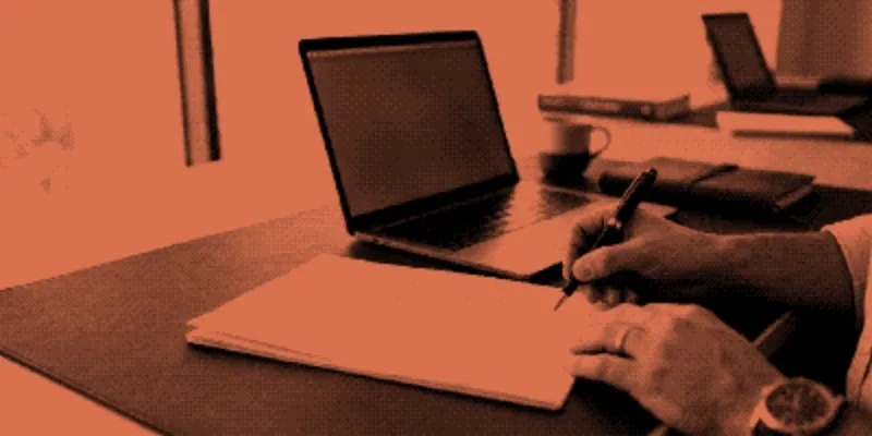 A person signing a printed employment contract at a desk