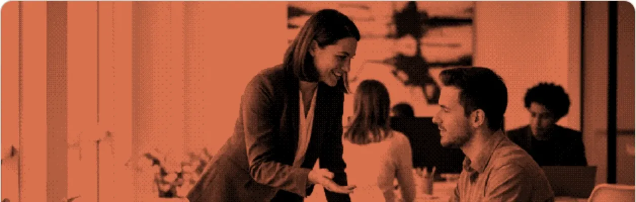 A recruiter in conversation with a candidate in an open office