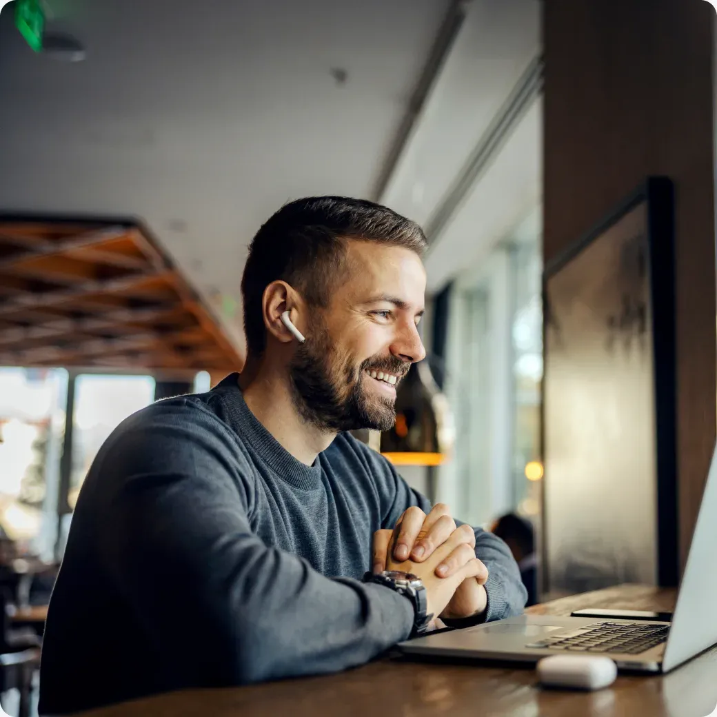 A professional working at a laptop in a bright Spanish workspace